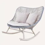 Mecedora amplia de mimbre sintético gris con cojines blancos y estructura metálica blanca
