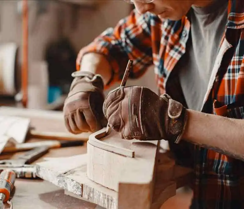 Carpintero artesano trabajando la madera en el taller
